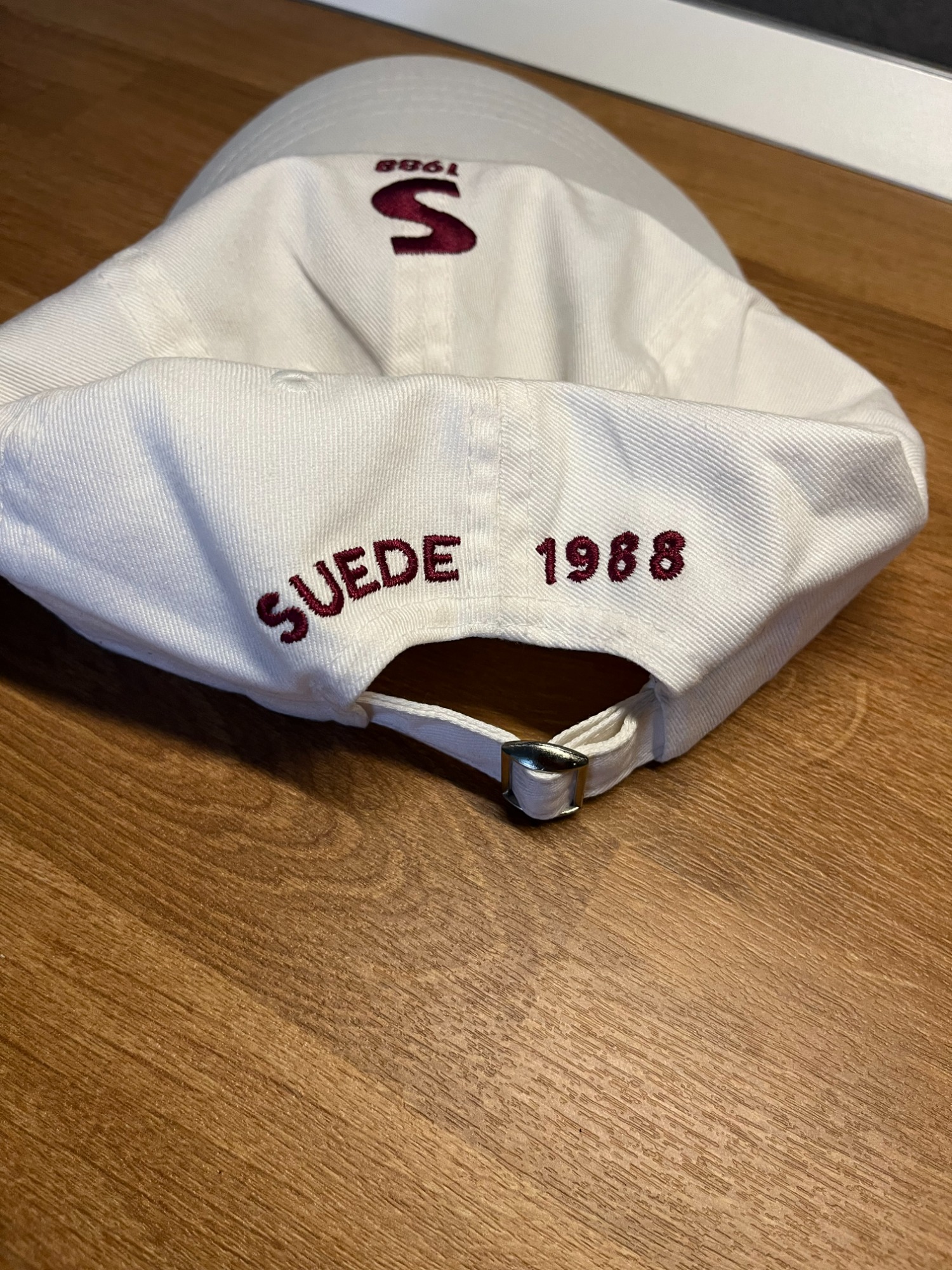 SUEDE1988 white cap, back view with SUEDE 1988 embroidery and metal strap buckle