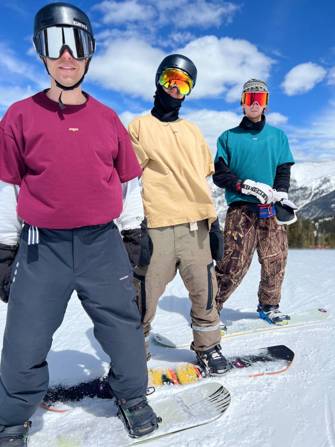 Three riders wearing SUEDE1988 tees on the hill